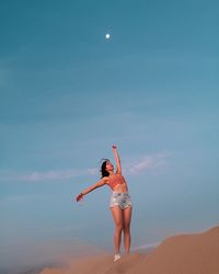 Full length rear view of woman standing against sky