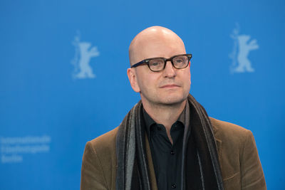 Portrait of man standing against blue background