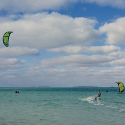 People enjoying in sea against sky