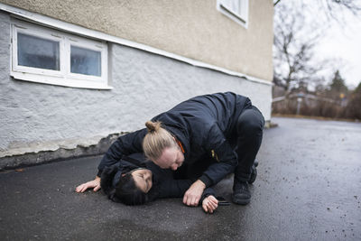 Man checking breath of unconscious woman in medical shock