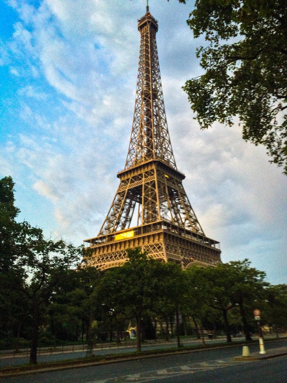 eiffel tower, architecture, built structure, tower, tall - high, famous place, international landmark, travel destinations, sky, culture, tourism, tree, capital cities, travel, building exterior, low angle view, city, cloud - sky, history, metal