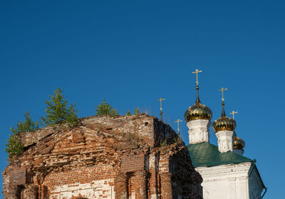 Golden domes and green trees over an ancient temple in the village of stromikhino, ivanovo region.