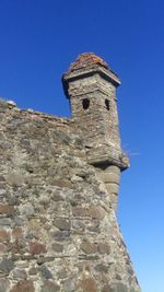 Low angle view of castle against clear blue sky