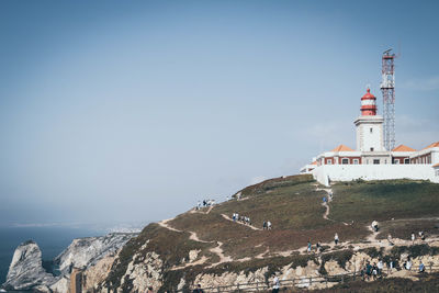 Lighthouse by sea against sky