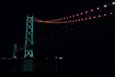 Low angle view of illuminated bridge against sky at night