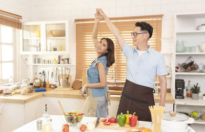 Young man and woman standing in kitchen