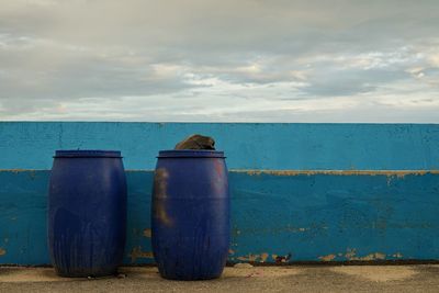 Metallic structure on sea shore against sky with the garbage bins.