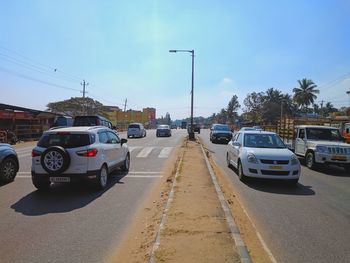 Cars parked on road against sky in city