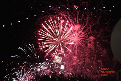 Low angle view of firework display at night