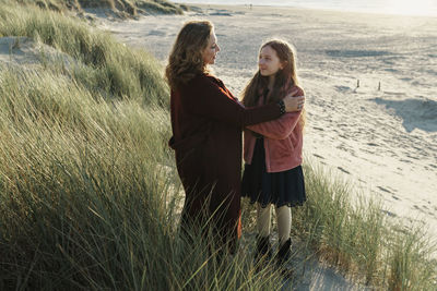 Woman with daughter standing on a land