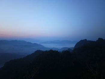 Scenic view of silhouette mountains against sky at sunset