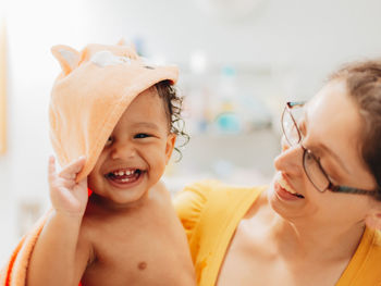 Portrait of smiling son with mother sitting at home