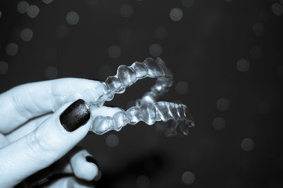 Cropped hand of woman holding plastic braces