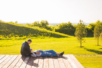 Man sitting on seat against clear sky