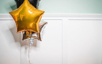 Tilt image of star shaped balloons hanging against wall