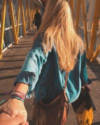 Rear view of woman standing on footbridge