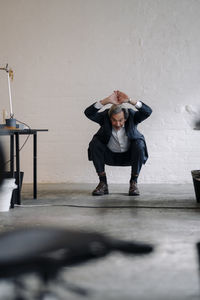 Senior businessman doing gymnastics in office