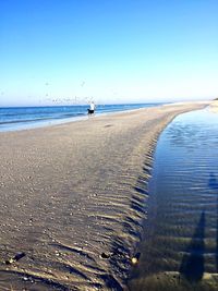 Scenic view of beach against clear blue sky