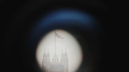 Close-up of clock tower against building in city