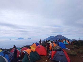 Group of people on mountain against sky