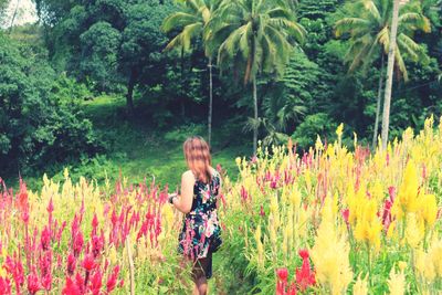 Rear view of woman standing against plants