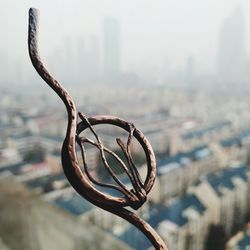 High angle view of rusty chain and city against sky