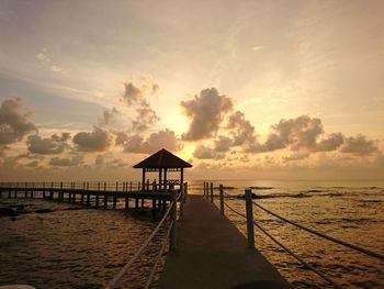 Lifeguard hut on beach against sky during sunset