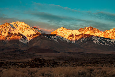 Scenic view of snowcapped mountains against sunrise sky