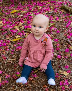 High angle view of cute baby girl sitting on land