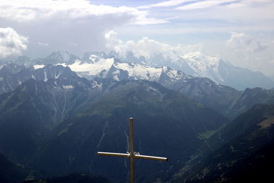 Scenic view of rocky mountains against sky from the summit with a cross