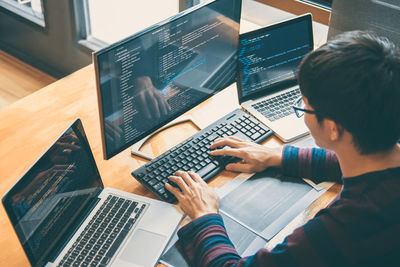 High angle view of computer programmer working on desk