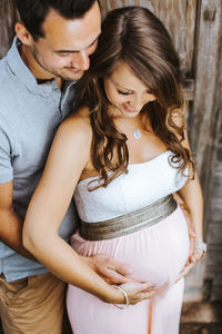 Man embracing pregnant woman at home