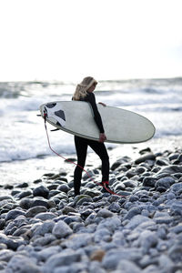 Woman with surfboard on beach