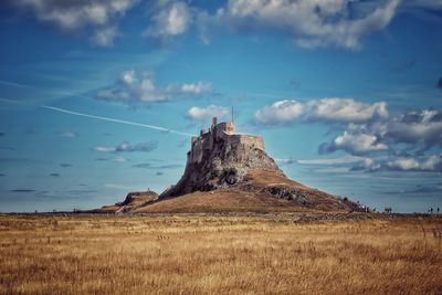 Scenic view of lindisfarne castle  and its hill