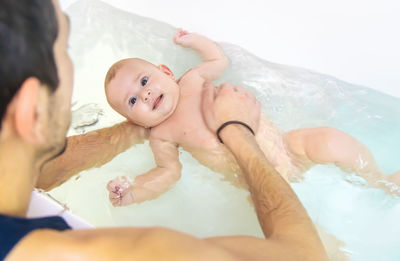 High angle view of mother and daughter in bathtub at home