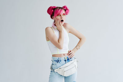 Young woman standing against white background