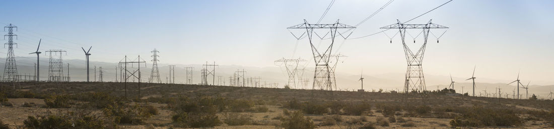 Electricity pylon on field against sky