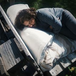 High angle view of young man sleeping on bench