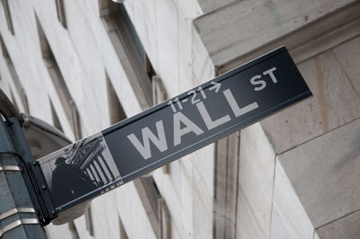 Low angle view of street sign wall street on road in manhattan