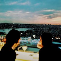 Woman photographing illuminated cityscape