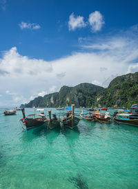 View of boats in sea against cloudy sky