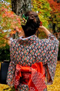 Rear view of woman sitting on bench
