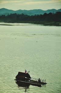 People on boat in sea against sky