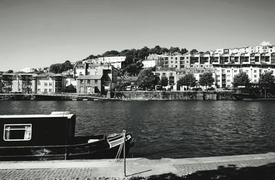 Scenic view of river by city against clear sky