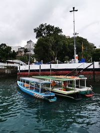 Boats moored in river against sky