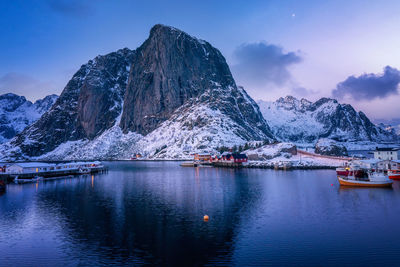 Scenic view of lake by snowcapped mountains against sky