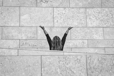 Rear view of man sitting on tiled floor