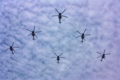 Low angle view of helicopters flying in sky