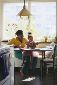 Mother and daughter sitting together at table