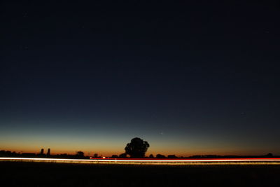 Scenic view of silhouette field against clear sky at night